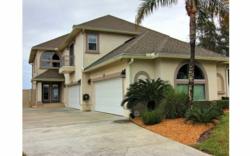 a 50-foot long cement driveway bordered by impeccable landscaping